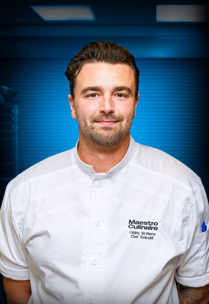 Portrait de Cédric St-Pierre, chef exécutif de Maestro Culinaire, partenaire du Centre des congrès de Québec, portant une veste de chef blanche.