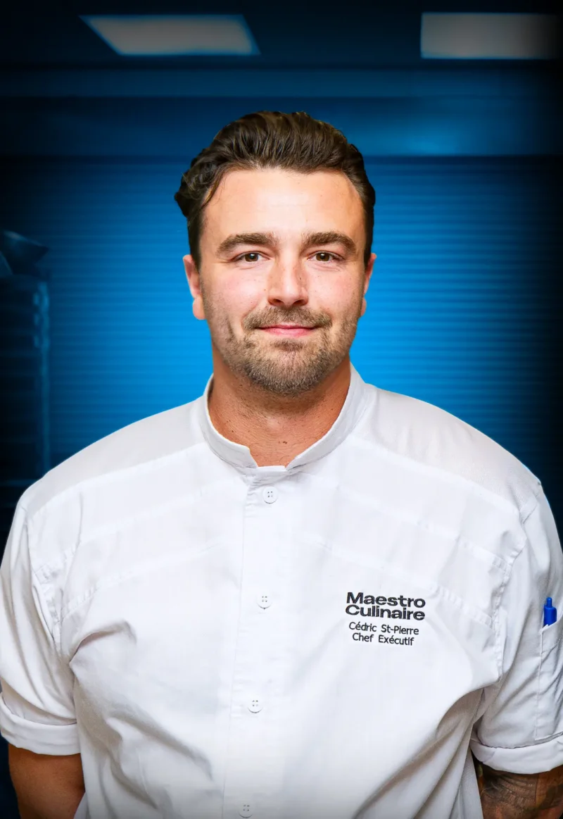 Portrait of Cédric St-Pierre, Executive Chef at Maestro Culinaire, partner of the Québec City Convention Centre, wearing a white chef’s jacket.